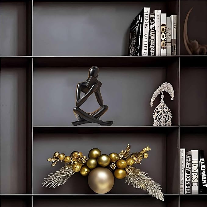 Black resin seated reading abstract figurine, angled view