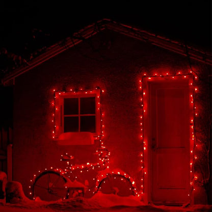 Red mini Christmas string lights outlining windows and doors on a building