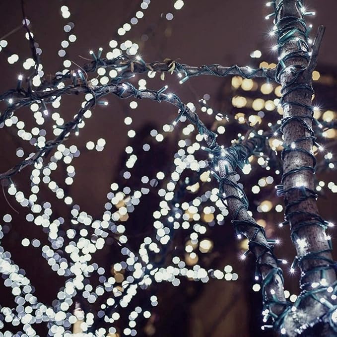 Mini LED string lights with round bulbs on dark wire, twinkling close-up.