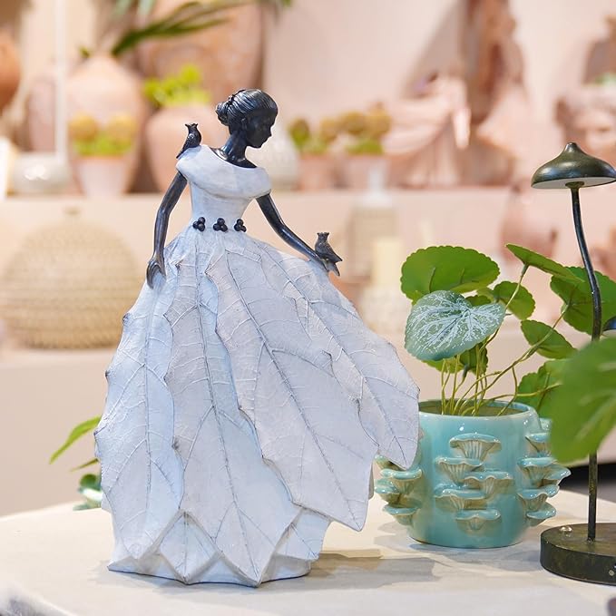 White resin fairy maiden statue on table decor with layered dress and bird in hand