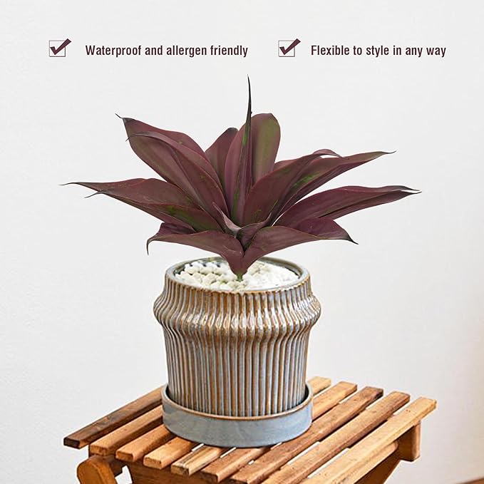 Purple-red artificial agave plant in a ribbed pot with a decorative wood base.