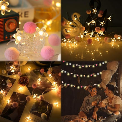 Cherry blossom string lights with flower LEDs and pink pom poms on a garland line