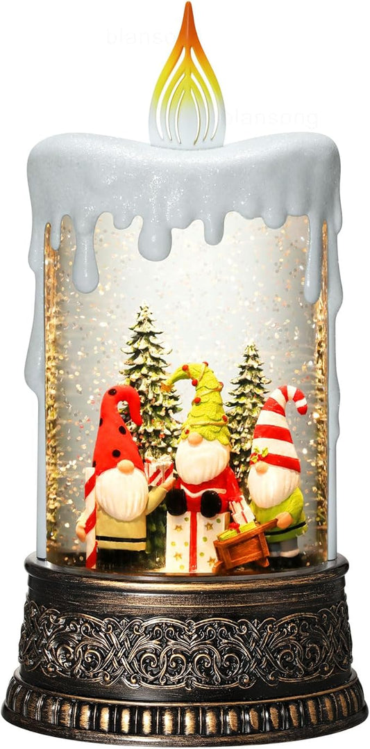 Lit snow globe candle decoration with Santa and elves, golden glittering snowfall