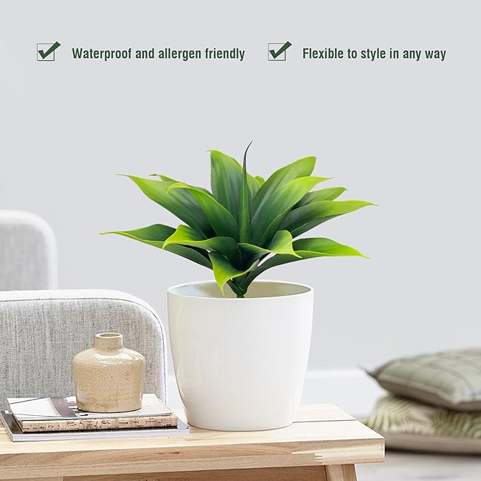 Green faux agave plant in white planter, spiky leaves