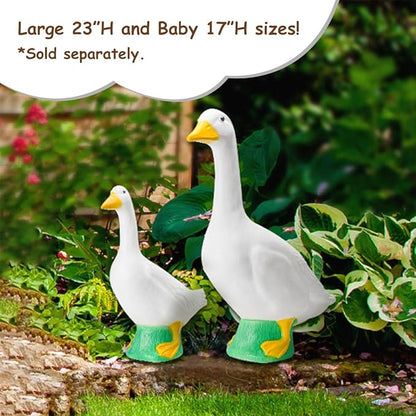 Large and small white goose statues with yellow beaks and green bases