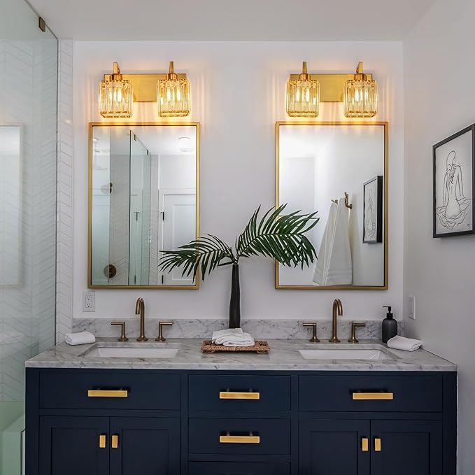 Gold 2-light vanity light with clear crystal glass shades over bathroom mirror