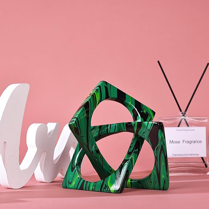 Interlocking geometric resin sculpture with glossy green, teal, and black swirled pattern