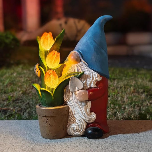 Solar garden gnome statue holding yellow tulips in a brown pot, blue hat.