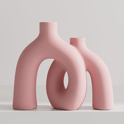 Light pink matte ceramic hug vase with conjoined donut sculpture, front view