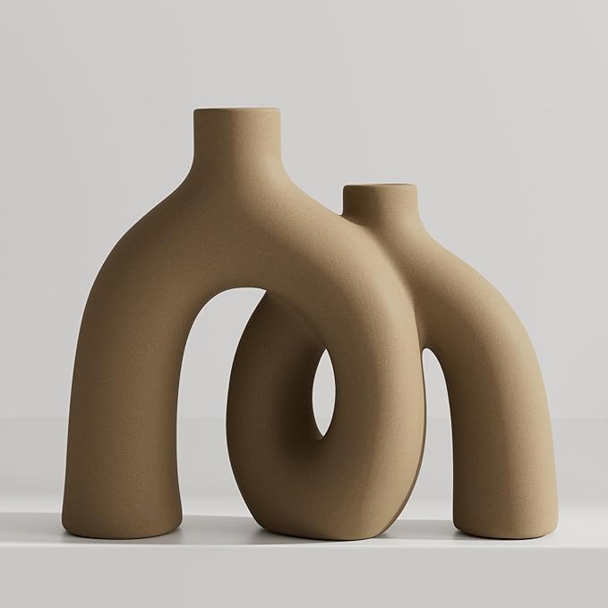 Matte tan-brown ceramic hug vase with conjoined donut sculpture, standalone.