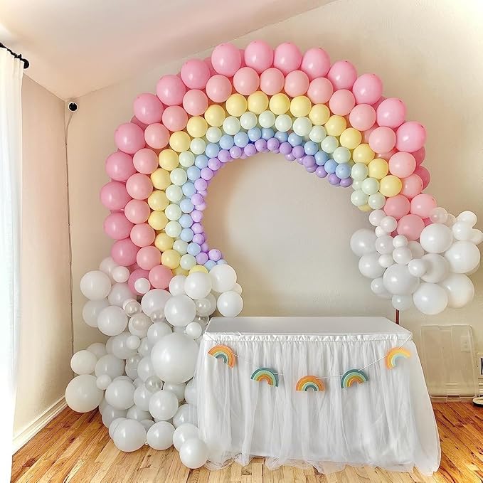 Rainbow balloon arch with pink, yellow, blue, purple, and white balloons around a white base