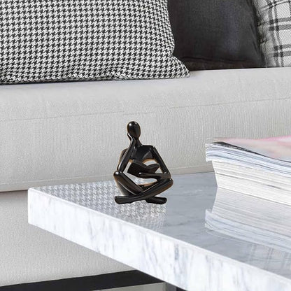 Zuo Si black resin reading thinker figurine on couch edge, holding an open book