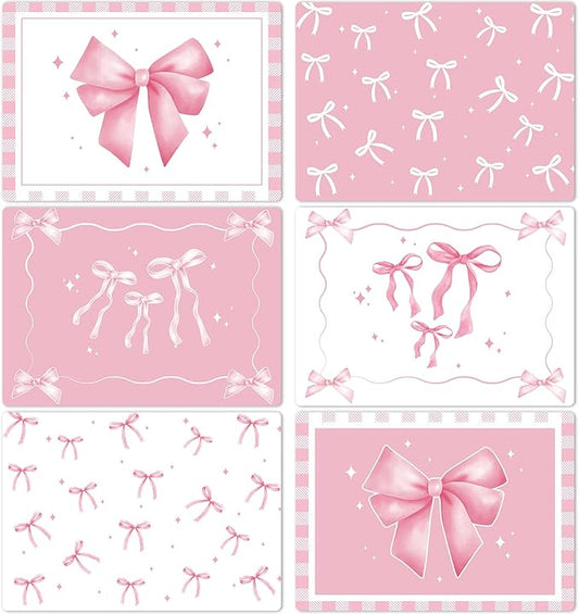 Set of 6 pink plastic placemats with bow and star patterns, rectangular