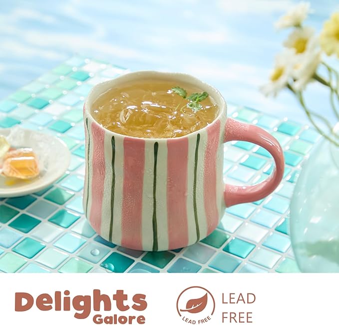 Close-up of striped ceramic mug with pink handle holding a hot drink