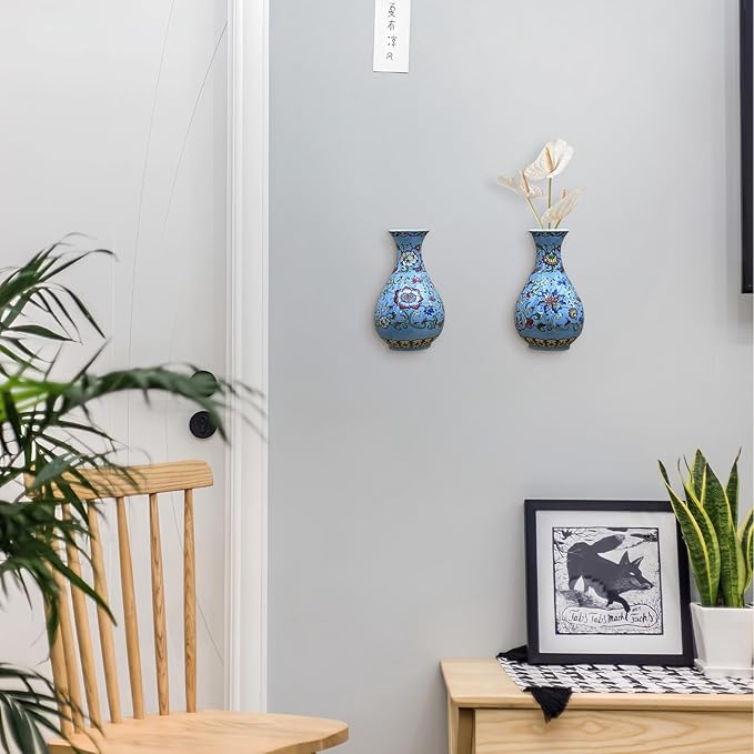 Two blue and white porcelain wall vases with floral design on a white wall