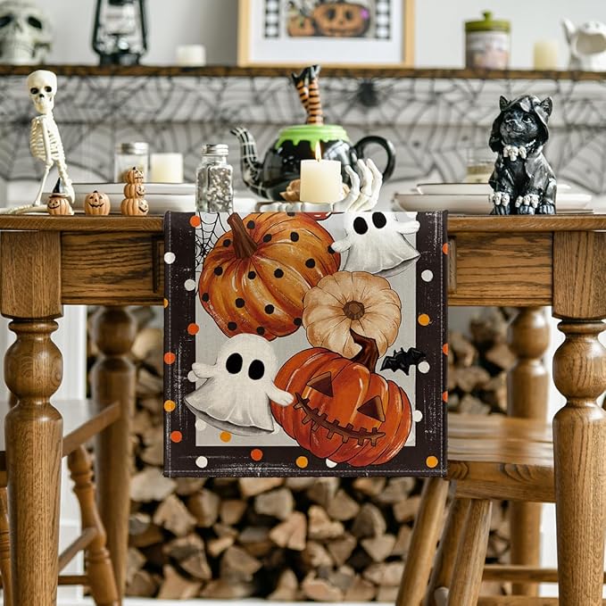Halloween table runner on dining table, featuring pumpkins, white ghosts, and spiderweb print