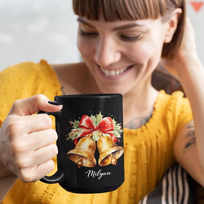 Black ceramic mug with bell and bow graphic and Milyan name, in use