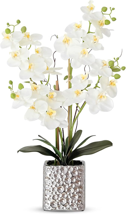 Faux white Phalaenopsis orchid arrangement with green stems in a silver textured vase