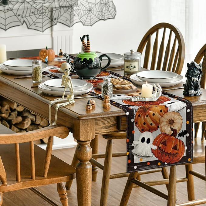 Halloween table runner with pumpkin, ghost, and spiderweb design along table edge