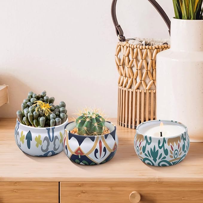 Blue patterned ceramic scented candle on a wooden table with potted succulents