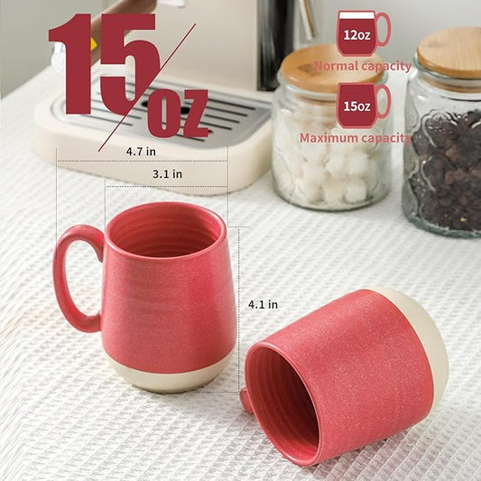 Pink ceramic coffee mug with handle, 15 oz capacity, shown with another mug.