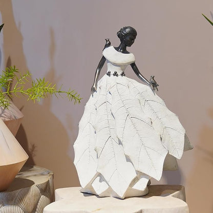 White resin fairy maiden statue on pedestal with layered skirt and bird figure