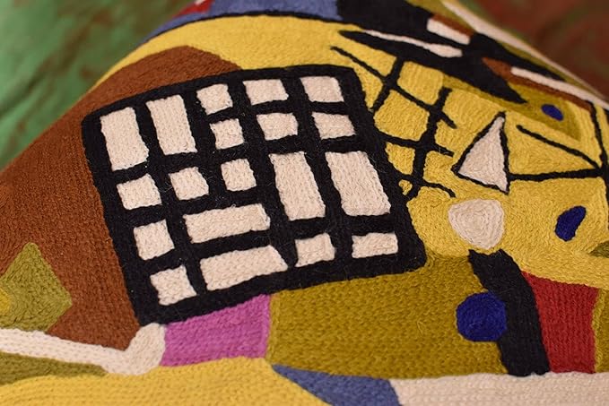 Abstract embroidered pillow cover closeup with black grid on brown and yellow
