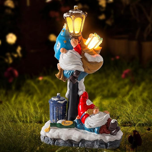 Lit solar garden gnome statue with glowing lanterns on round stone base