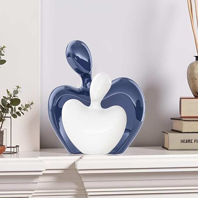 Blue and white ceramic heart-shaped hugging couple figurine on display, glossy finish.