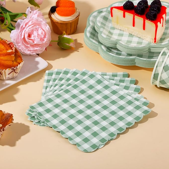 Sage green gingham napkins and plates laid out with party desserts and cupcakes