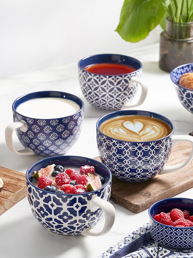 Blue-and-white ceramic coffee or soup mugs with handles, one with latte and berries.