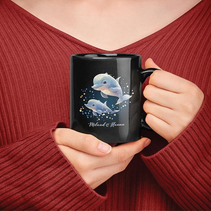 Black mug with blue dolphin Christmas graphic and custom name, held near chest