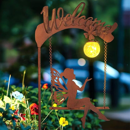 Solar fairy garden light close-up with rust stake, fairy cutout, and glowing amber sphere