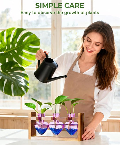 Wood plant propagation station with three purple heart-shaped glass vases and green seedlings