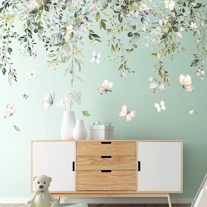 Botanical wall decal with green leaves, butterflies, and vine branches overhead