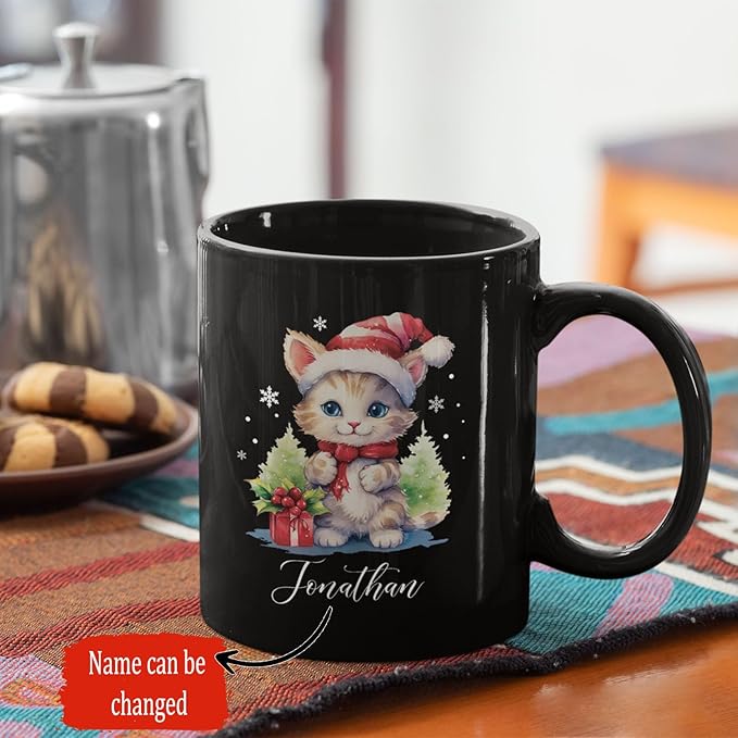 Black 11oz mug showing kitten in Santa hat, wreath, and 'Jonathan' text.