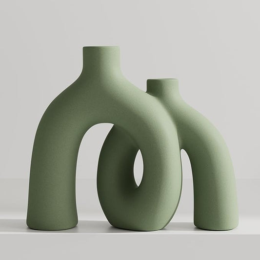 Matte sage green ceramic conjoined hug vase with two donut cutouts, two heights