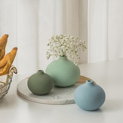 Ceramic bud vase set with three rounded mini vases in sage, mint, and light blue