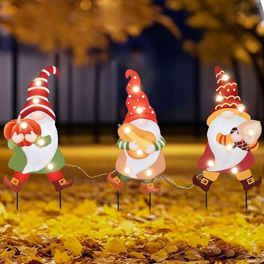 Three LED-lit gnome yard stakes with red hats and white beards, autumn holiday decor
