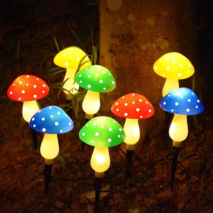 Group of glowing solar mushroom LED lights with red, blue, green, and yellow spotted caps