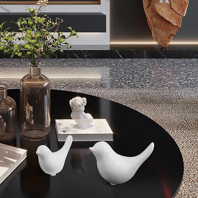 Ceramic white bird figurine set of 2 on black tabletop, one facing left and one right