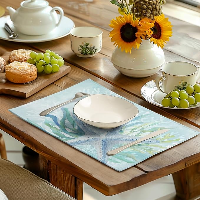 Teal blue starfish and seaweed placemat on a wooden table with teapot and cups