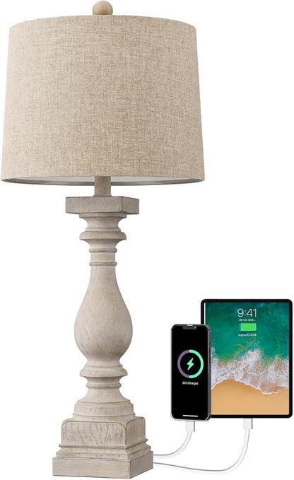 Farmhouse table lamp with beige fabric shade and visible USB charging ports on base