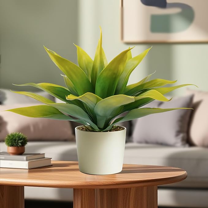 Faux agave plant with yellow-green leaves in a white pot on a tabletop