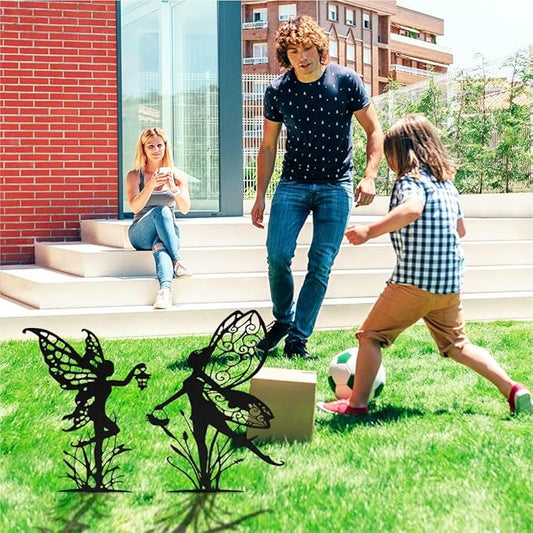 Black metal fairy garden stakes on lawn, featuring three different fairy silhouettes
