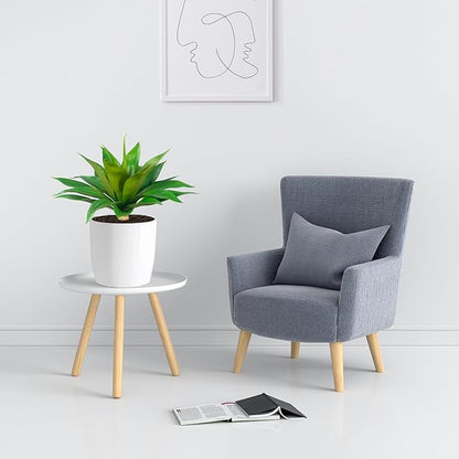 Green faux agave plant on a small table next to a gray armchair
