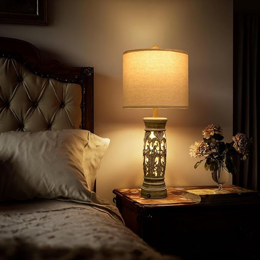 Rustic farmhouse table lamp with beige fabric shade and ornate carved base