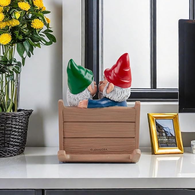 Garden gnome couple rocking chair statue viewed from behind, kissing, red and green hats