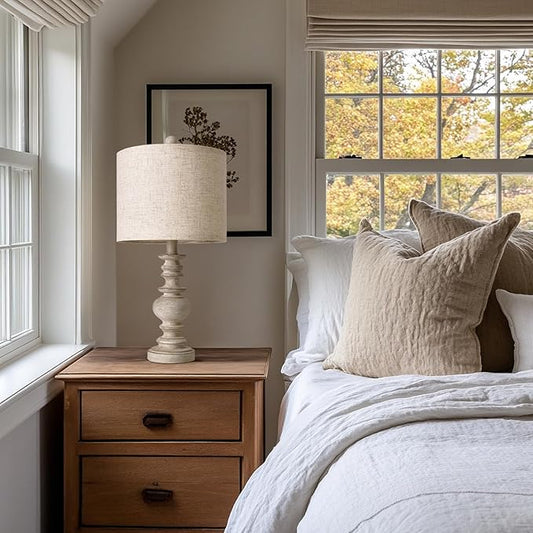Rustic table lamp with beige linen drum shade on turned light resin pedestal base