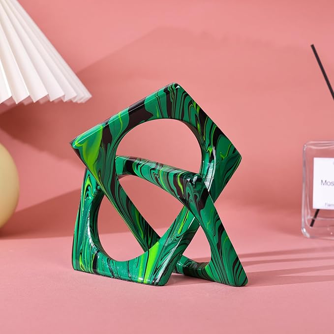 Green and black marbled resin sculpture with interwoven geometric loops, viewed at an angle